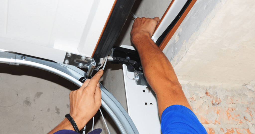 Technician tightens garage door cable.