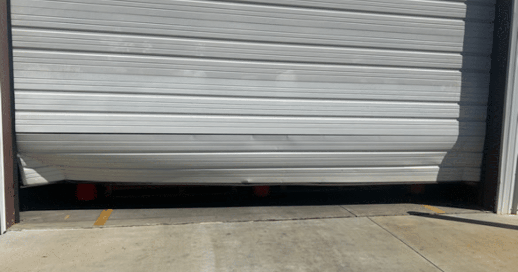 Damaged garage door stuck near the ground.