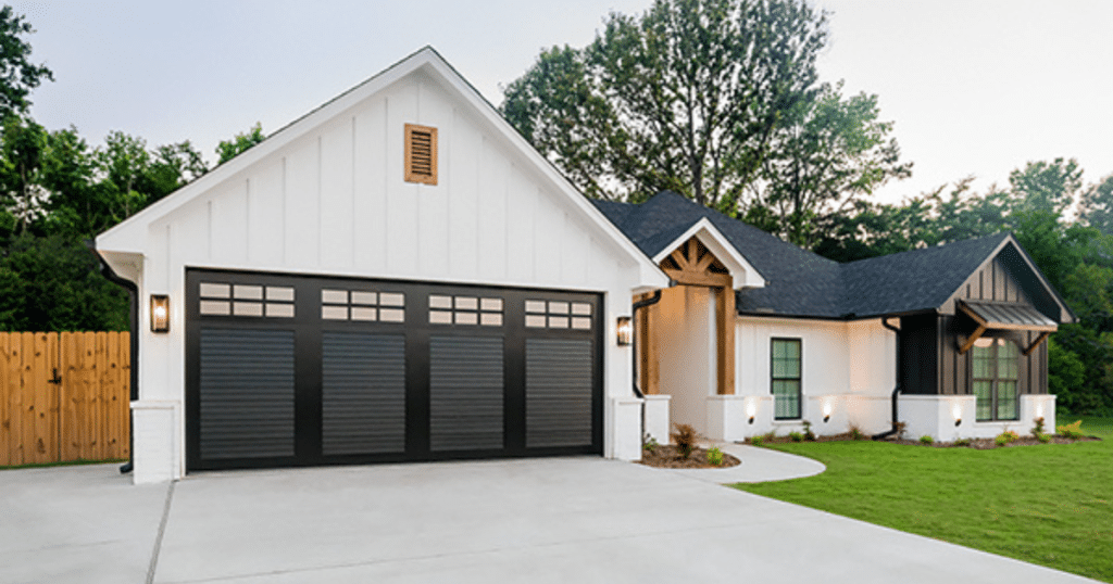 black garage door and a white house
